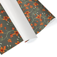 Rolls of gift wrap featuring orange flowers and green vines on a dark gray background. Illustrated by Lisel Ashlock.