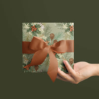 Hand holding wrapped gift with holly, berries, and pinecones pattern on mint background with terracotta bow. Illustrated by Lisel Ashlock.