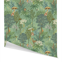 Woodland-themed gift wrap featuring forest animals, mushrooms, ferns, and flowers on a soft green background. Illustrated by Lisel Ashlock.