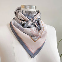 Angelite silk cotton scarf in soft pink and gray tones with botanical leaf design, draped on mannequin. Illustrated by Lisel Ashlock.
