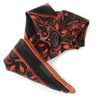 Black and red filigree patterned silk cotton scarf with brown edges draped diagonally. Illustrated by Lisel Ashlock.