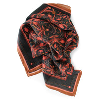 Bright mahogany filigree silk cotton scarf with red ornamental florals on black background and cognac border, illustrated by Lisel Ashlock.