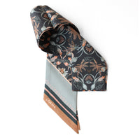 Silk twill twilly scarf in moonstone with dark floral and celestial eye pattern design illustrated by Lisel Ashlock.