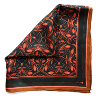 Silk twill scarf with black background, red and gold ornamental filigree flowers, and cognac border. Illustrated by Lisel Ashlock.