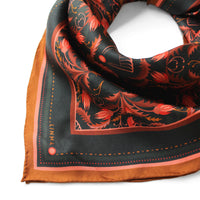 Silk twill scarf with dark charcoal background, bright red and orange filigree floral pattern, and mahogany border. Illustrated by Lisel Ashlock.