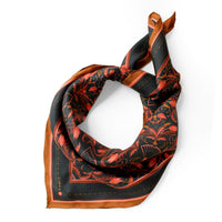 Silk twill scarf in bright mahogany with red filigree floral pattern on dark background, displayed flat. Illustrated by Lisel Ashlock.
