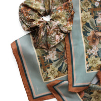 Folded silk twill scarf in midnight hellebore pattern with gathered scrunchie detail. Illustrated by Lisel Ashlock.