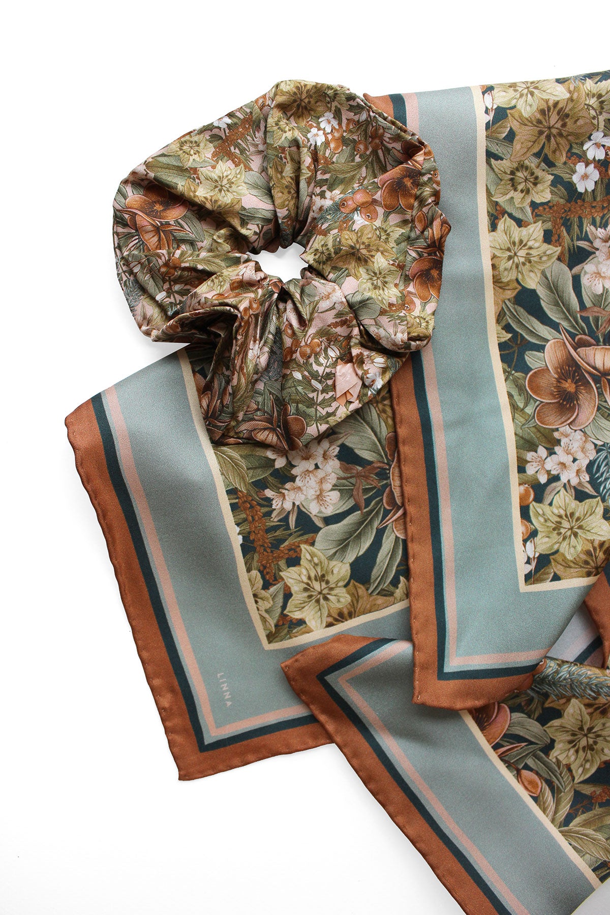 Folded silk twill scarf in midnight hellebore pattern with gathered scrunchie detail. Illustrated by Lisel Ashlock.