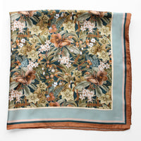 Silk twill scarf with floral pattern featuring brown flowers, white blossoms, and green leaves on dark background, bordered in light blue and rust. Illustrated by Lisel Ashlock.