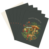 Stack of green greeting cards with hare and mushroom botanical illustration and "Happy Birthday" text. Illustrated by Lisel Ashlock.