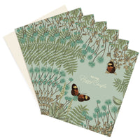 Multiple greeting cards featuring botanical illustrations with butterflies and "To the Happy Couple" text. Illustrated by Lisel Ashlock.