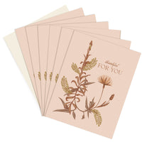 A stack of blush pink greeting cards with botanical illustrations and "thankful FOR YOU" text. Illustrated by Lisel Ashlock.