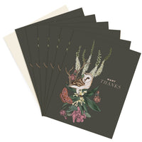 A stack of "Many Thanks" greeting cards featuring an illustrated barn owl surrounded by florals and botanicals on a dark background. Illustrated by Lisel Ashlock.