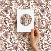 Hand holding blank greeting card featuring circular owl and floral design against matching patterned background. Illustrated by Lisel Ashlock.