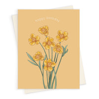 A birthday greeting card featuring yellow buttercup flowers with green stems on a cream background. Illustrated by Lisel Ashlock.