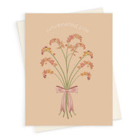 Greeting card with "celebrating you" text and illustration of pink wildflower bouquet with ribbon on beige background. Illustrated by Lisel Ashlock.