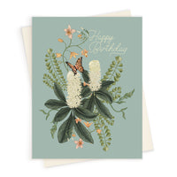 Happy Birthday greeting card featuring white flowering cherry laurel with orange blossoms, green foliage, and a butterfly on sage green background. Illustrated by Lisel Ashlock.