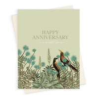 Anniversary greeting card with pale green background, botanical garden illustration featuring two birds and flowering plants, text reads "Happy Anniversary I'm so grateful for you". Illustrated by Lisel Ashlock.