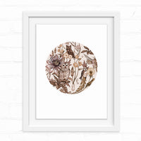 Circular botanical illustration featuring three owls nestled among flowers and foliage in sepia tones, framed in white. Illustrated by Lisel Ashlock.