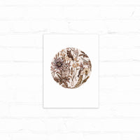 Circular botanical illustration in brown sepia tones featuring owls, flowers, and woodland foliage. Illustrated by Lisel Ashlock.