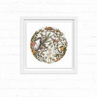 Circular illustration of a guereza monkey among botanical elements with chameleon and bird, framed in white. Illustrated by Lisel Ashlock.