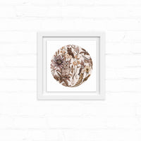 Circular sepia-toned illustration of owls among flowers and botanicals in a white frame on shiplap. Illustrated by Lisel Ashlock.