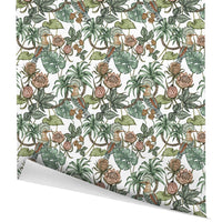 Decorative gift wrap featuring a botanical pattern with tropical flowers, birds, and foliage in green and brown tones. Illustrated by Lisel Ashlock.