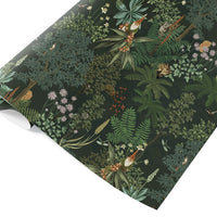 Rolled botanical gift wrap with ferns, wildflowers, and woodland gnomes on dark green background. Illustrated by Lisel Ashlock.
