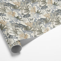 Rolled gift wrap featuring botanical illustrations with flowers, leaves, butterflies, and trees in muted greens, taupes, and blues. Illustrated by Lisel Ashlock.