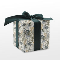 A square gift box wrapped in botanical patterned paper with a dark green ribbon bow. Illustrated by Lisel Ashlock.