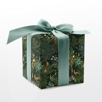 A wrapped gift box with dark green botanical pattern and sage green ribbon bow, Illustrated by Lisel Ashlock.