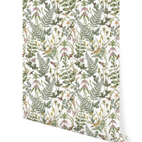 Rolled wallpaper featuring botanical illustrations with ferns, flowers, and insects on a white background. Illustrated by Lisel Ashlock.