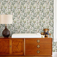 Secret Garden Wallpaper in white with botanical illustrations behind mid-century wooden dresser. Illustrated by Lisel Ashlock.