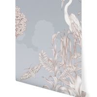 Night Heron Mural in Mist featuring a white heron, flowering lilacs, hanging flowers, and a moth on blue-gray wallpaper. Illustrated by Lisel Ashlock.
