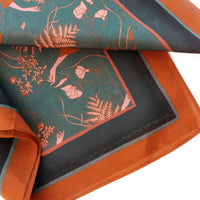 Folded viridian silk cotton scarf with coral botanical illustrations of ferns and flowers. Illustrated by Lisel Ashlock.