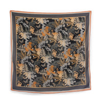 Square silk cotton scarf featuring monkeys, tropical leaves, and butterflies in orange, cream, and gray on black background. Illustrated by Lisel Ashlock.