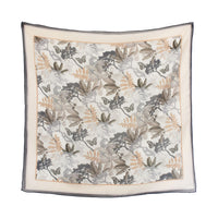 Square silk cotton scarf featuring botanical illustrations with birds, butterflies, and foliage in taupe, cream, and charcoal tones. Illustrated by Lisel Ashlock.