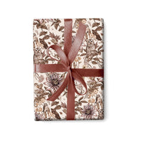 A wrapped gift with brown and cream owl and floral patterned paper tied with a mauve ribbon bow. Illustrated by Lisel Ashlock.